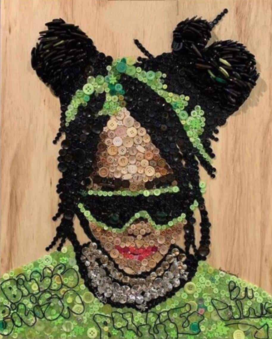 Billie Eilish button art. Made  from hundreds of buttons, beads, etc. on a wooden background and a handmade black stained frame. It measures 30” high x 24” wide. 