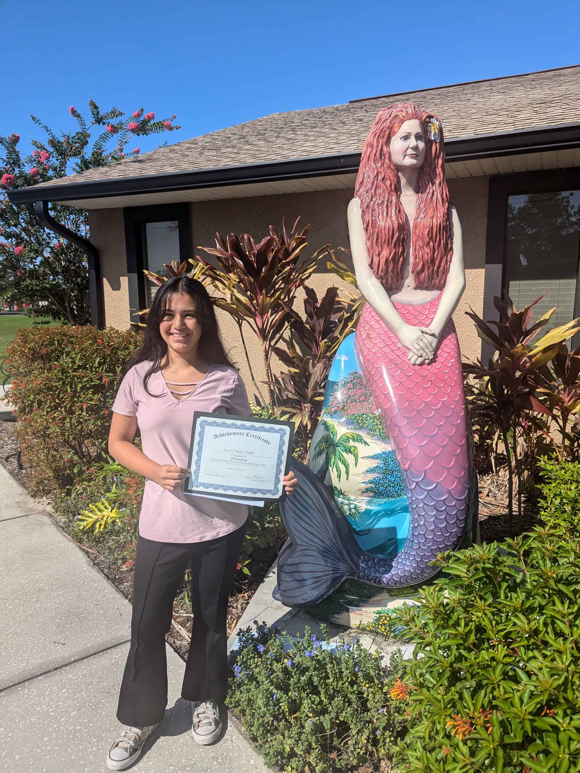 Aurora "Banjoe" Valdes Age 12 receives her certificate and $50 award for her entry, "A world without the United States."