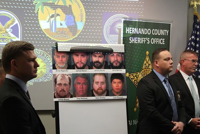 The photographs of all eight perpetrators is displayed while being flanked by investigators and those involved with the operation. [Hernando Sun Staff]