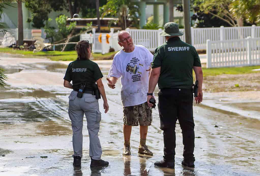 Hernando County Deputies discuss needs with a Hernando Beach resident who rode out the storm. [Credit: Mark Stone]