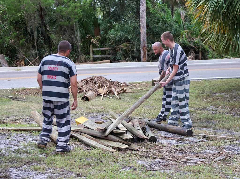 County jail inmates pitch in to help clean up debris at Bayport Park. [Credit: Mark Stone]