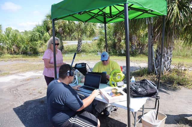 Volunteers LJ Johns and William Cooper create a “work order” for a residents needing assistance. [Credit: Mark Stone]