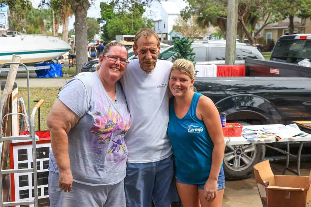 Jennifer Campbell (L) and Rochelle Boyle (R) stand with Tim Boyle outside the Hernando Beach home where Boyle nearly lost his life in storm surge. [Credit: Mark Stone]