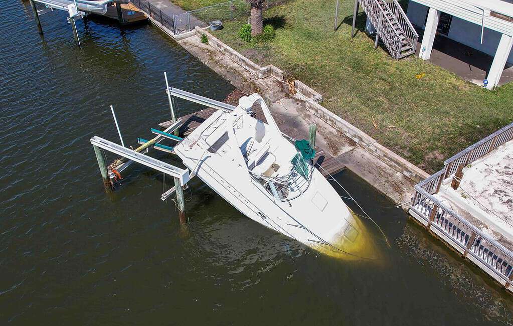 A boat sits partially submerged in a canal. [Credit: Mark Stone]