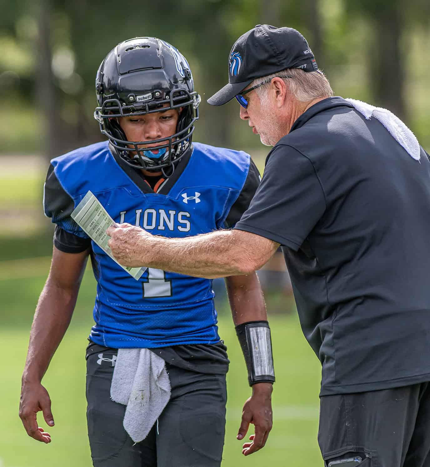 Hernando Christian Academy QB, 1, Jaden Montzka gets instructions from Head Coach David Raley during the game with Ocala Christian Friday afternoon in Brooksville. [Photo by Joe DiCristofalo]