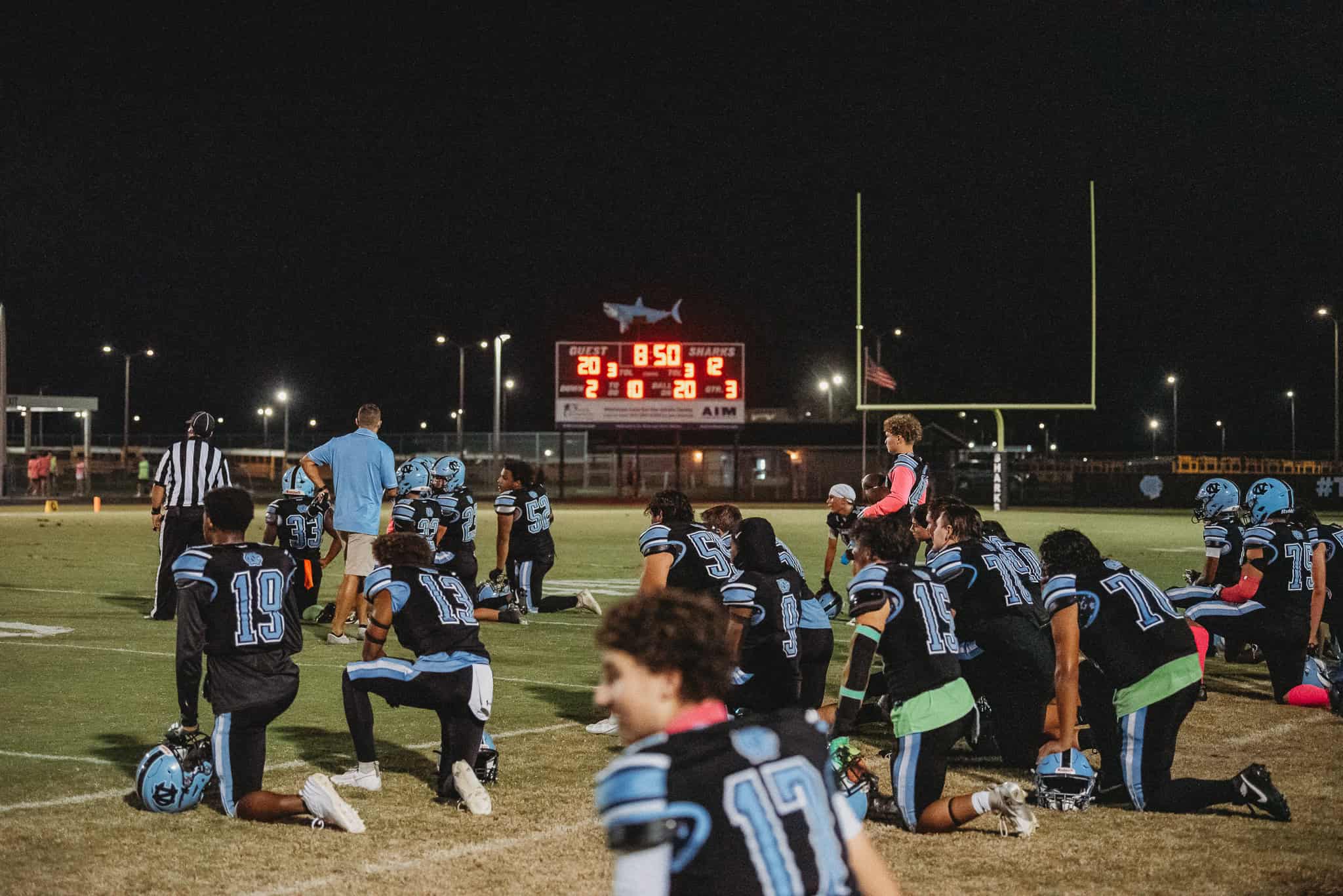 Nature Coast Sharks takes a knee for injured player on the field. [Photo by Cynthia Leota]