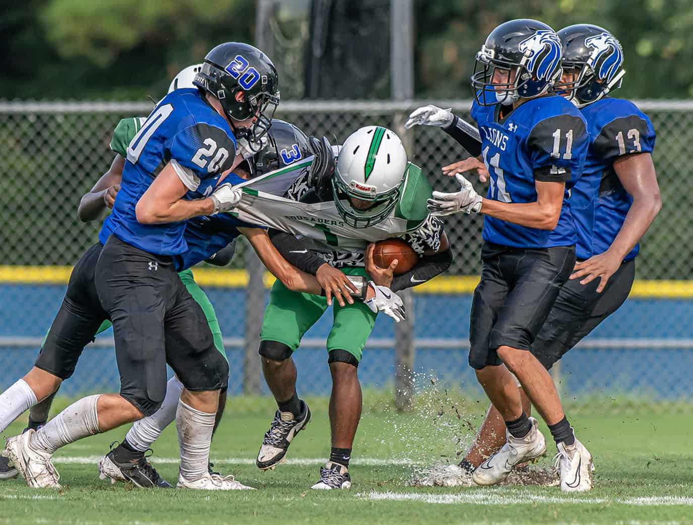 Hernando Christian Academy ,20, Layton Boggs, 11, Camdyn Twardosky and 13, Tayvion Howard combine to bring down Ocala Christian runner ,1, Brandon Norman Jr Friday afternoon in Brooksville. [Photo by Joe DiCristofalo]