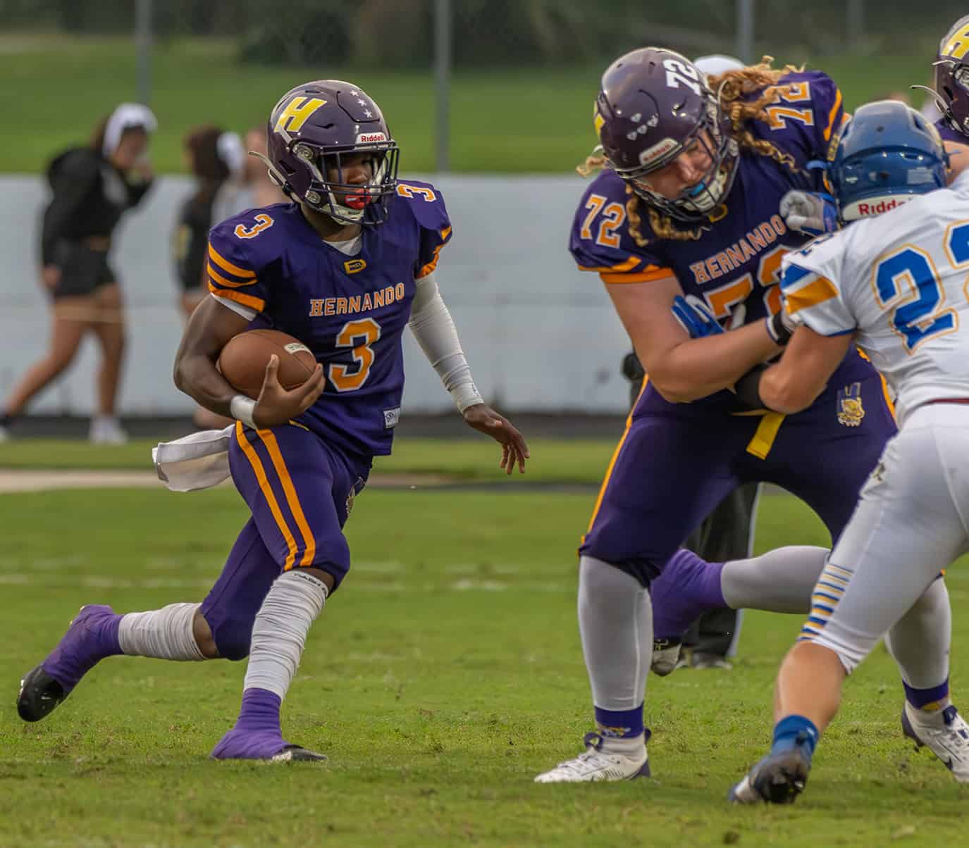 Hernando High, 3, Jerry Brown runs for a gain aided by the blocking of, 72, Wiley Blair duriny the game with visiting Crystal River High School. [Photo by Joe DiCristofalo]