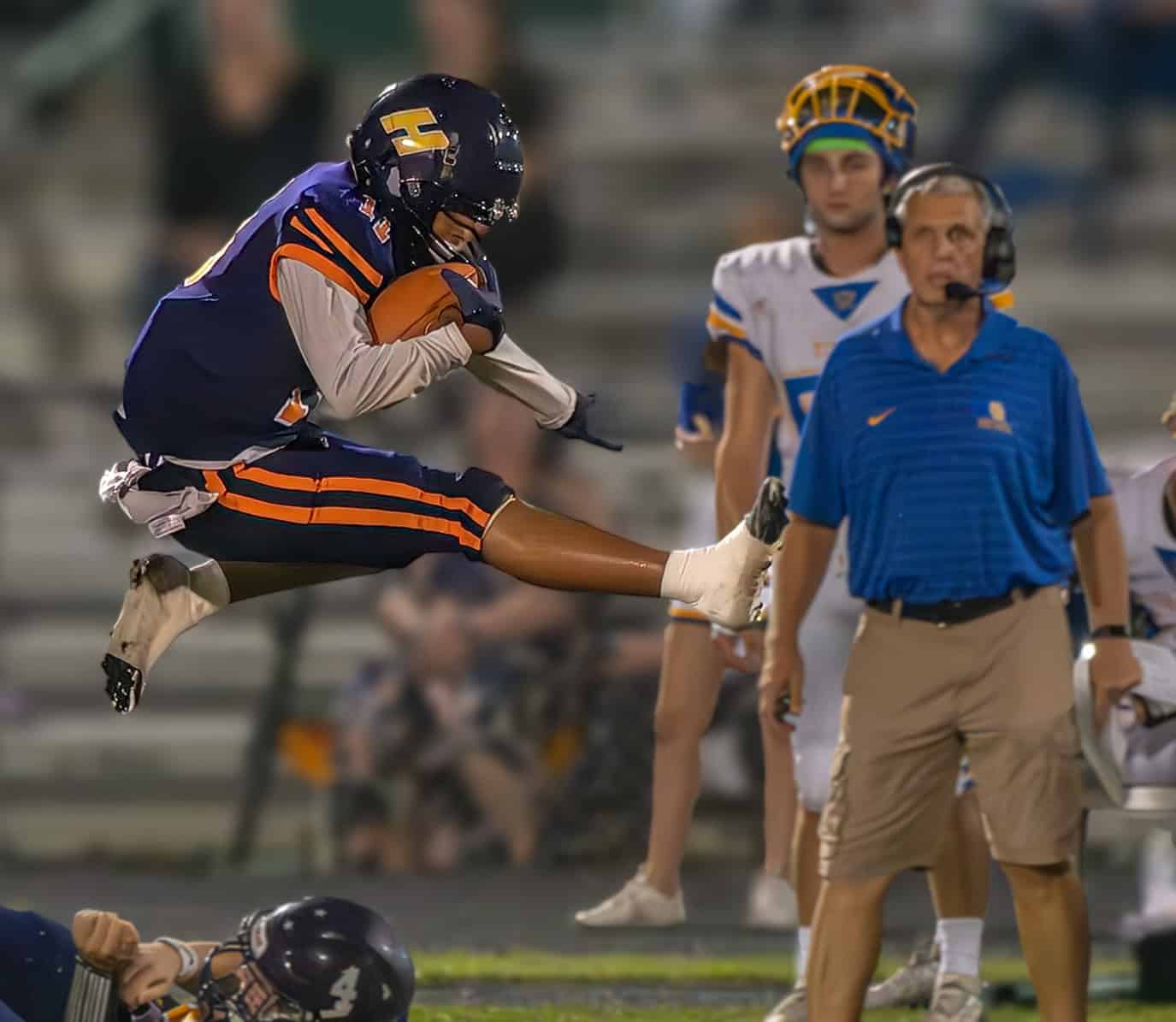 Hernando High , 11, Kamoni Dotson hurdles over a team mate  on the way to a big gain against Crystal River High School Friday night in Brooksville. [Photo by Joe DiCristofalo]