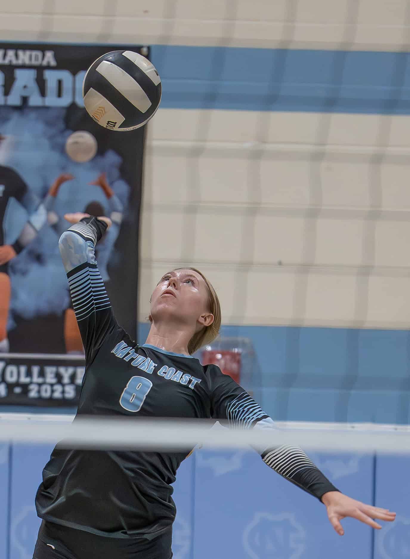 Nature Coast Tech, 8, Addy Carpenter goes high for a kill shot in the match with visiting Hernando High. [Photo by Joe DiCristofalo]