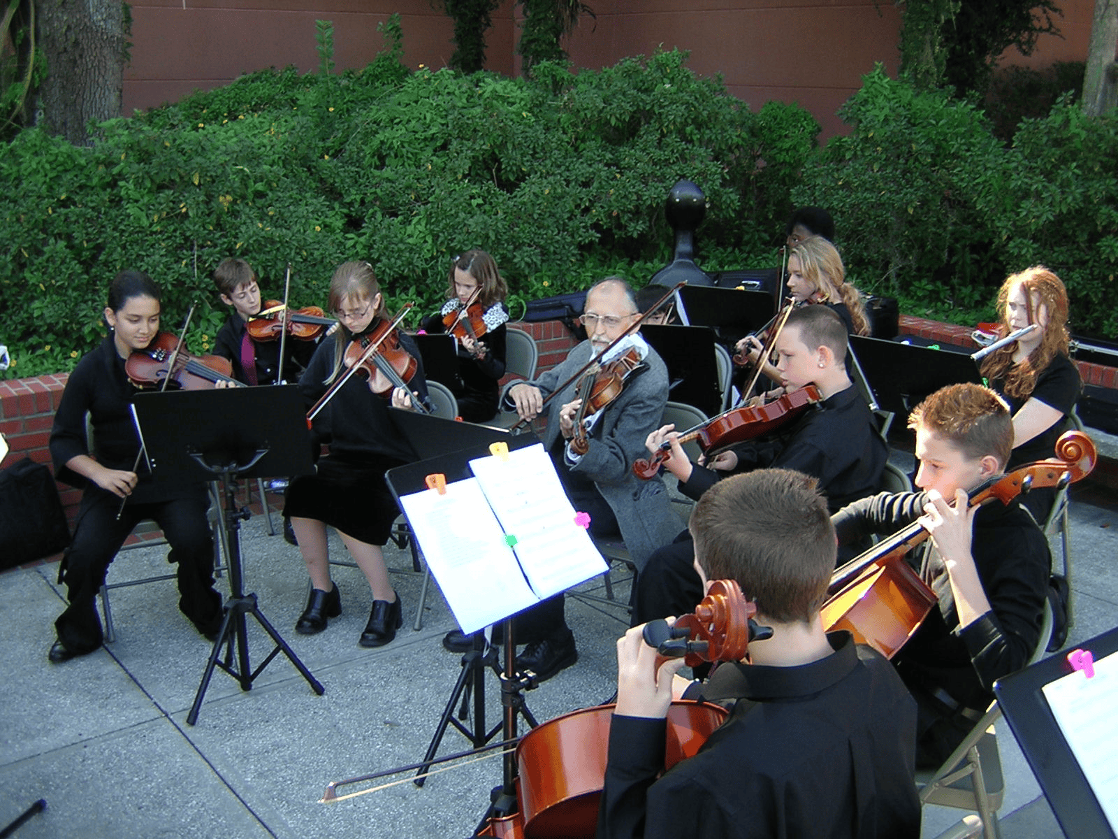 Co-founder George Rubis (center) surrounded by Youth Orchestra members performing their first concert. [Courtesy photo]