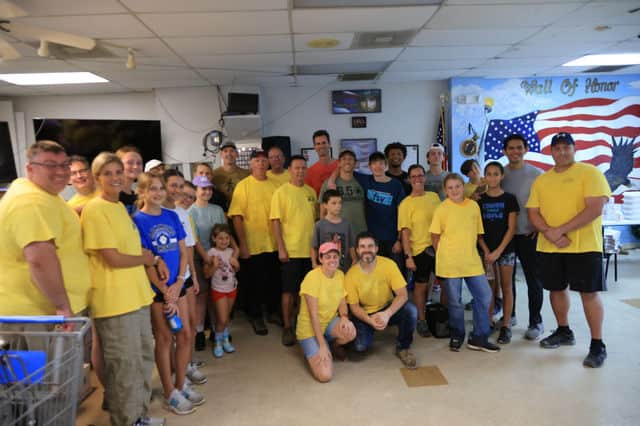 Organizers and work teams from the Church of Jesus Christ of Latter Day Saints pose for a group photo during a brief break at the team’s command post on Sunday. [Photo: Mark Stone / FMN]