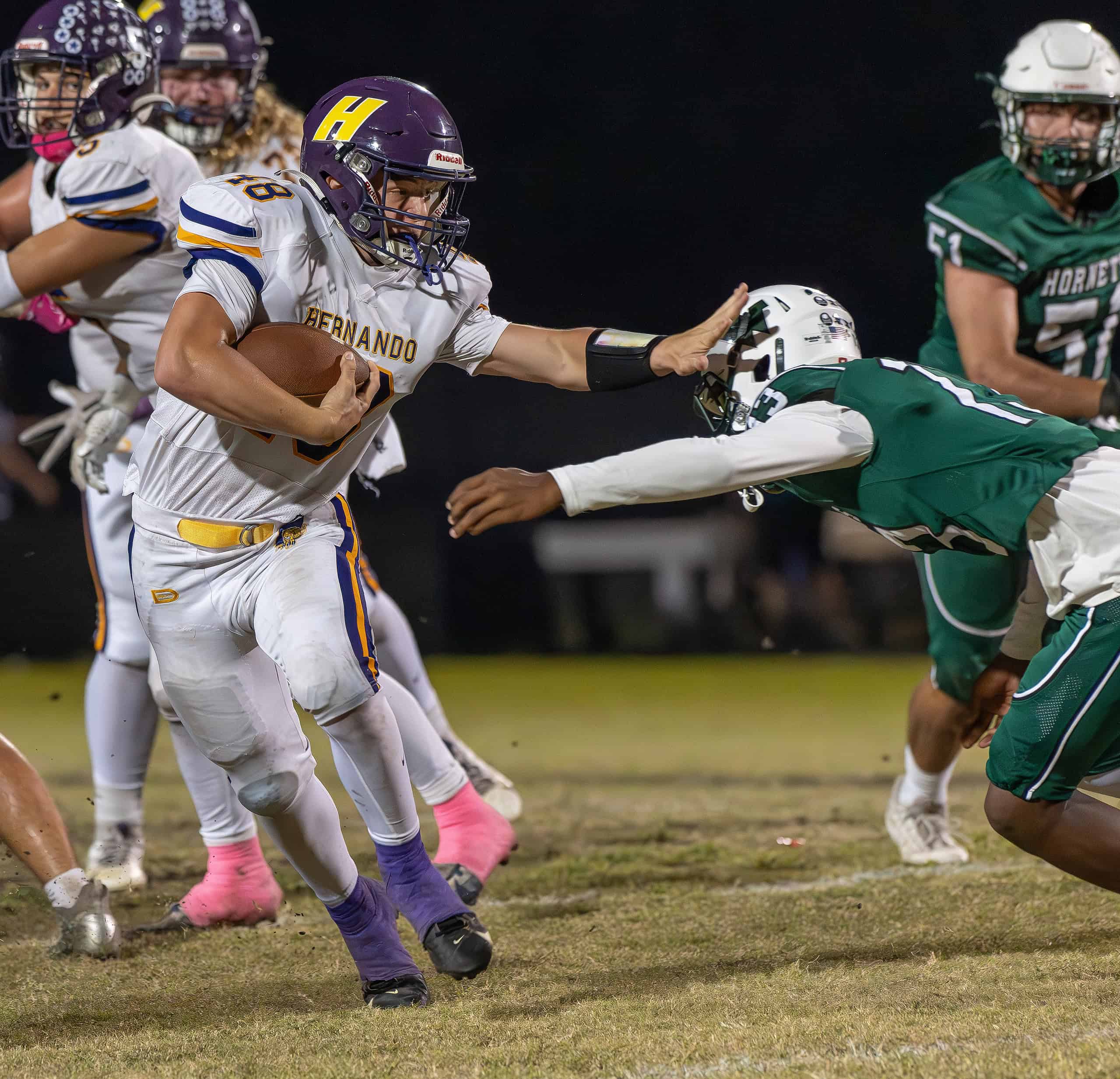 Hernando High, 48, works a stiff arm for a few extra yards Friday at Weeki Wachee High, [Photo by Joe DiCristofalo]