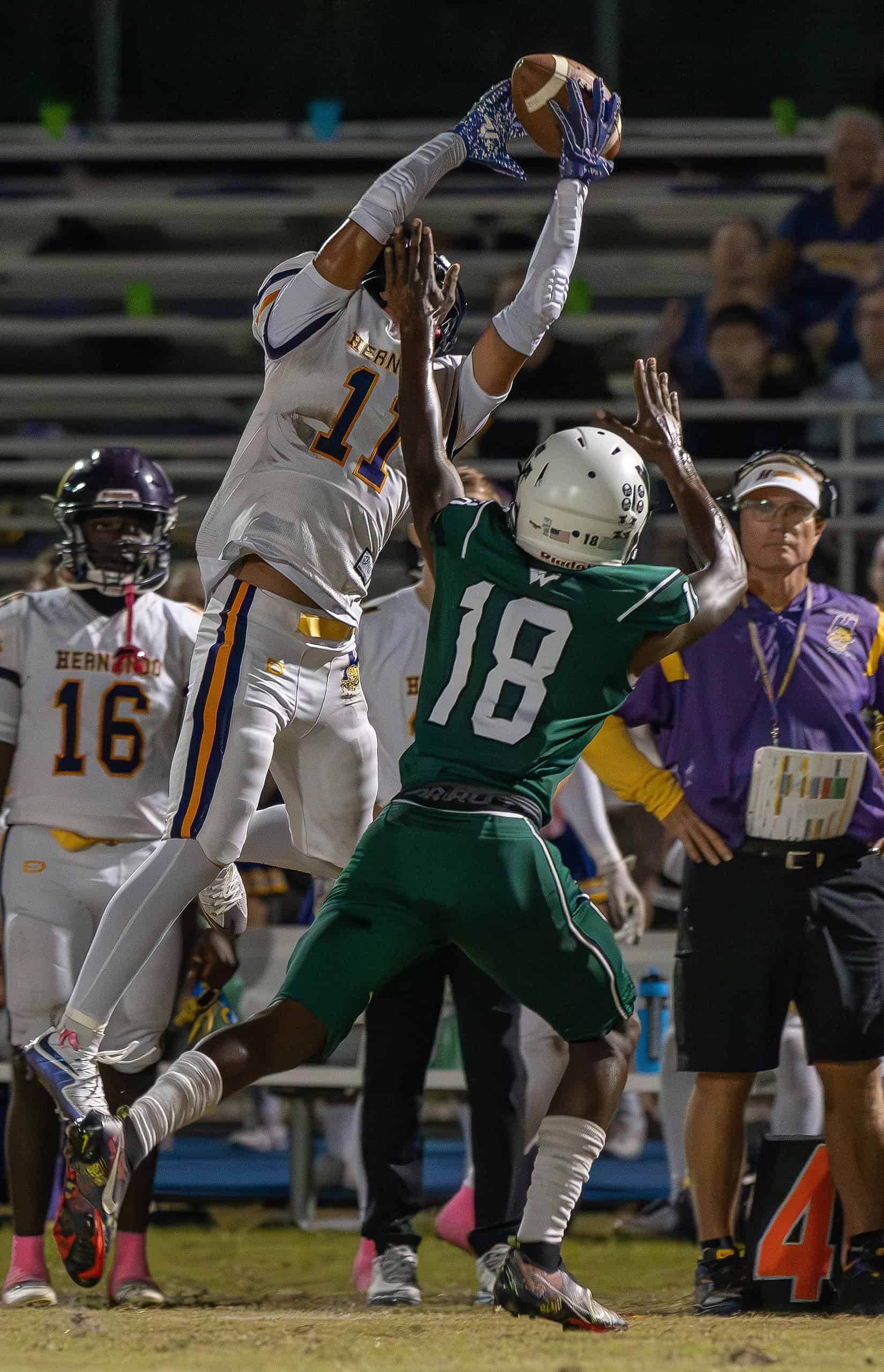 Hernando High, 11, Kamoni Dotson had this catch attempt broken up by Weeki Wachee High, 18, Elle Royal-Brown Friday at Weeki Wachee High [Photo by Joe DiCristofalo]