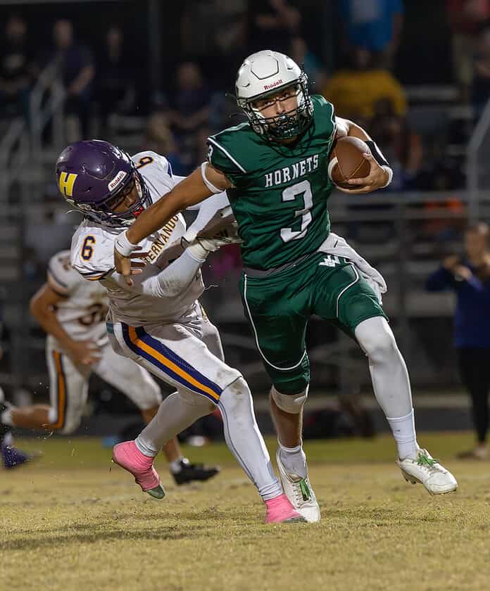 Weeki Wachee High QB, 3, Richard Hanshaw eludes Hernando High's ,6, Nick King for a long gain. [Photo by Joe DiCristofalo]