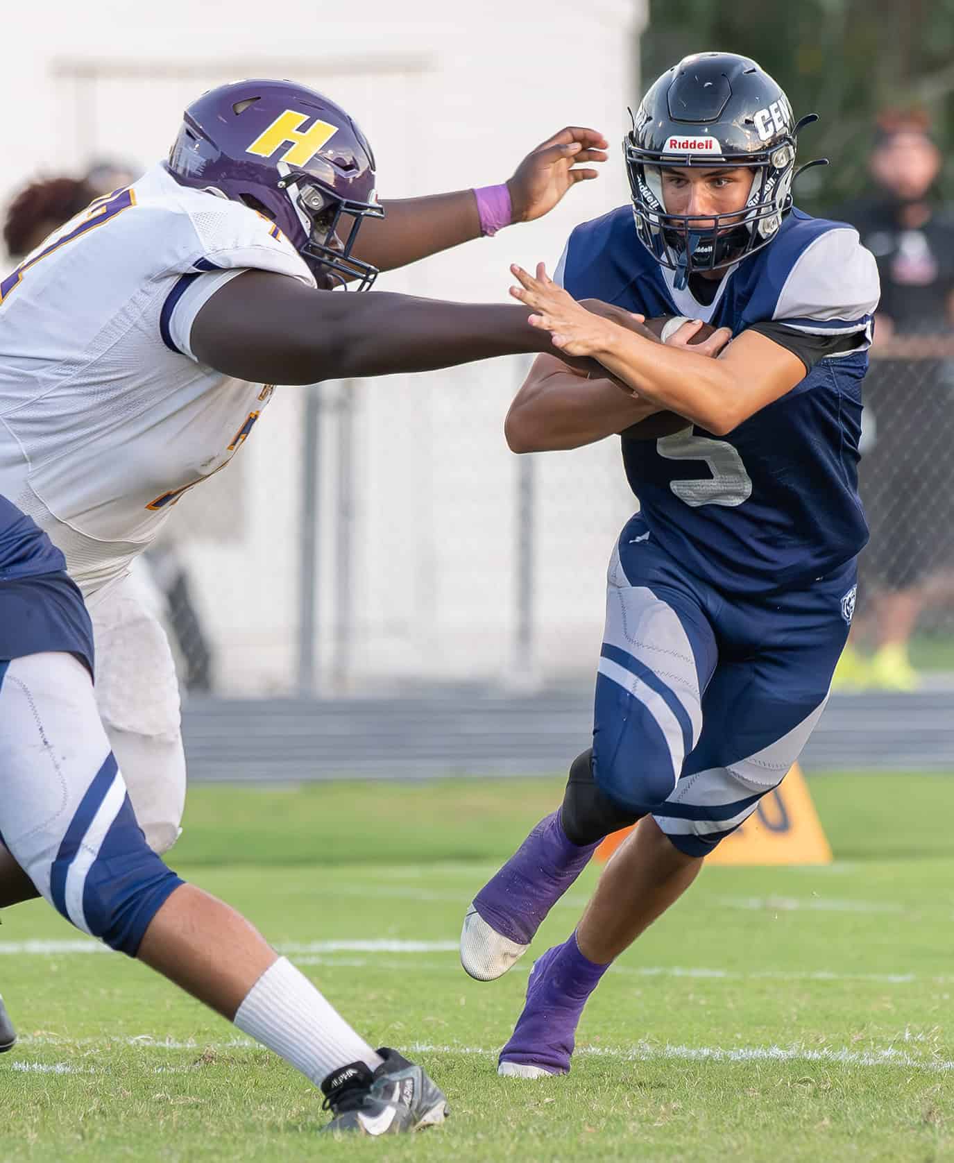 Central High's Quarterback, 5, Niko Demos tries to elude the grasp of Hernando High, 77, Evan Richards. [Photo by Joe DiCristofalo]