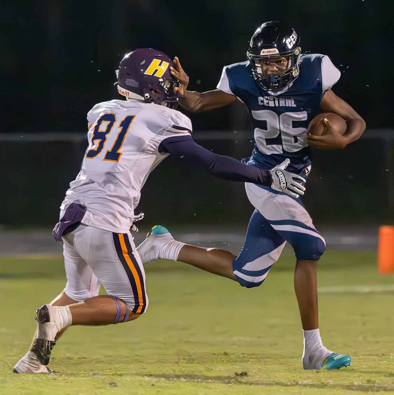 Central High's, 26, Samuel Jackson uses a stiff arm to ward off a tackle attempt by Hernando High, 81, Braden White. [Photo by Joe DiCristofalo]