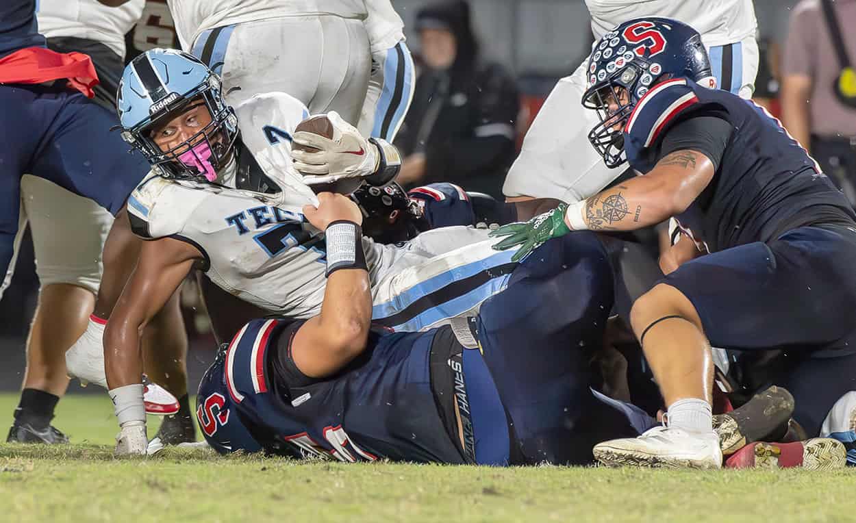 Nature Coast Tech, 7, LJ Elwin stretches for extra yardage in the grasp of Springstead defenders, 55, Andrew Clarkson and 8, Mykel Theirault Friday at Booster Stadium. [Photo by Joseph DiCristofalo]