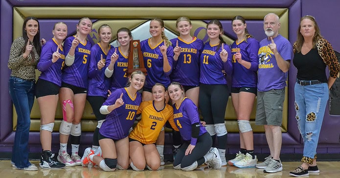 Hernando High's volleyball team celebrates winning a district championship on its home floor on Thursday night. [Credit: Chris Bernhardt Jr.]