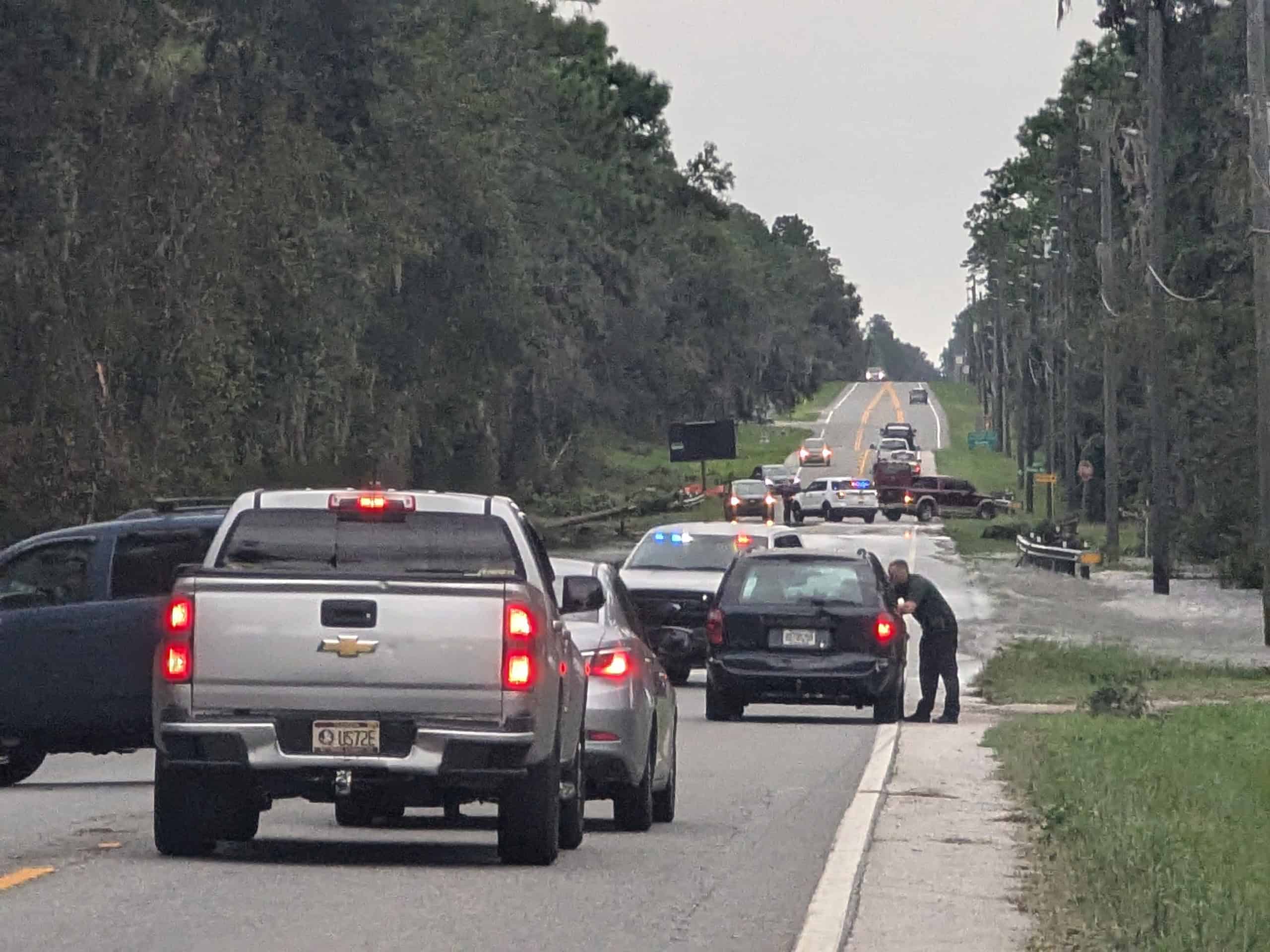 An officer turns drivers around ahead of deep water running over Hwy 41 in Brooksville.