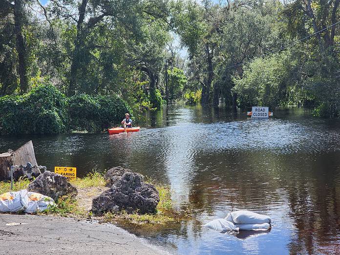 A kayaker paddles over a flooded roadway in the Ridge Manor / West Lake community, Oct. 21, 2024. [Photo by Austyn Szempruch]