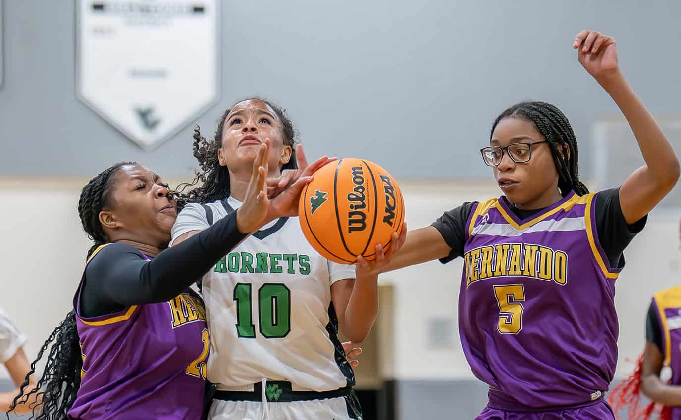 Weeki Wachee, 10, Genesis Beal has a shot attempt stymied by Hernando High, Tamia Williams and, 5, Philisha Bennett. [Photo by Joe DiCristofalo]