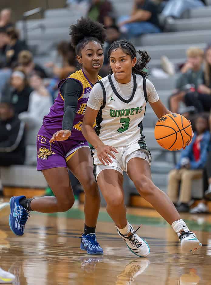 Weeki Wachee, 3, Joelys Rodriguez works around the defense by Hernando High, 23, Ayana Kincade. [Photo by Joe DiCristofalo]