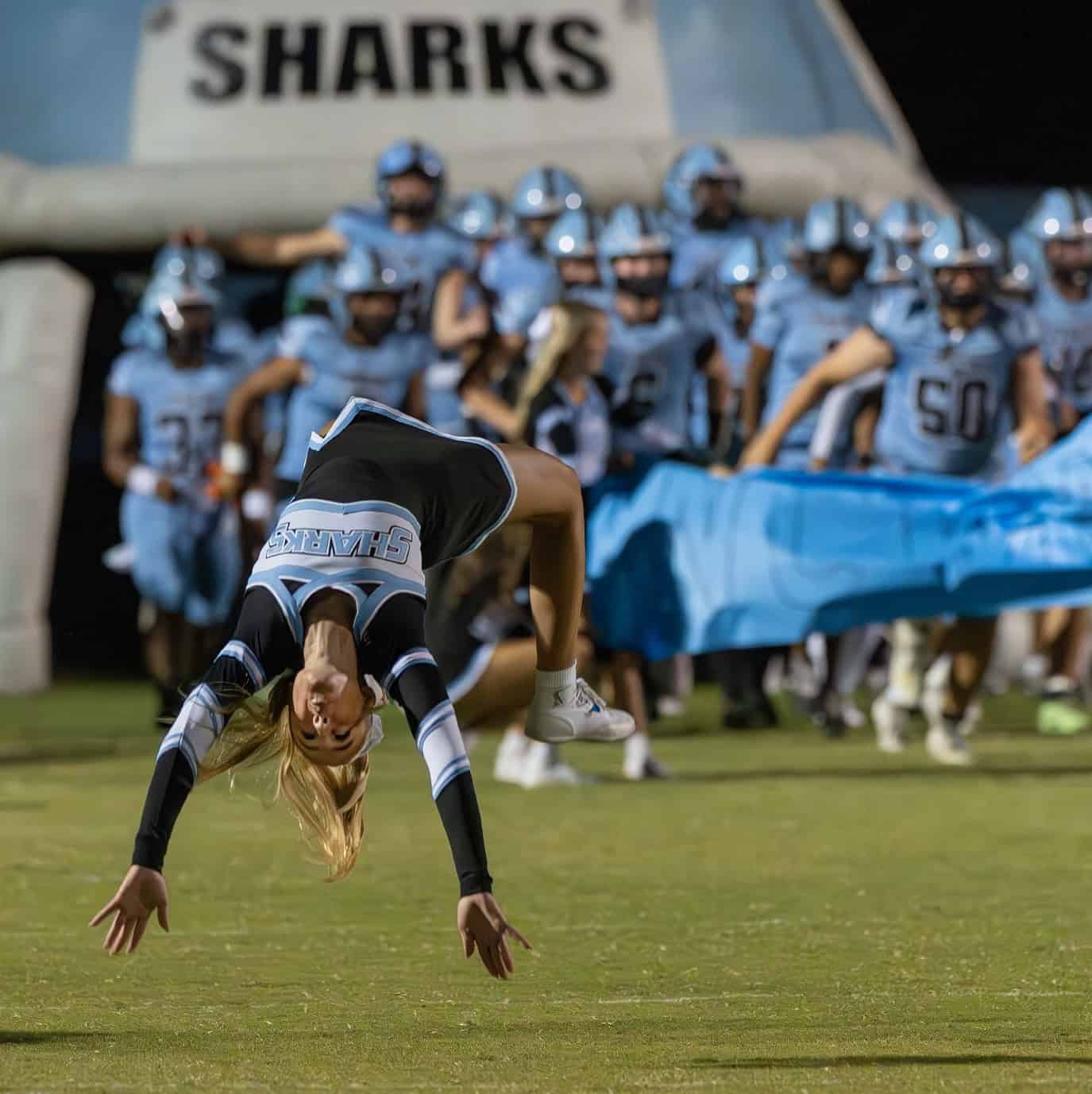 Nature Coast cheerleader Rebecca Johnson flips as the Sharks take the field before the Homecoming game versus visiting rival Hernando High. [Photo by Joe DiCristofalo]