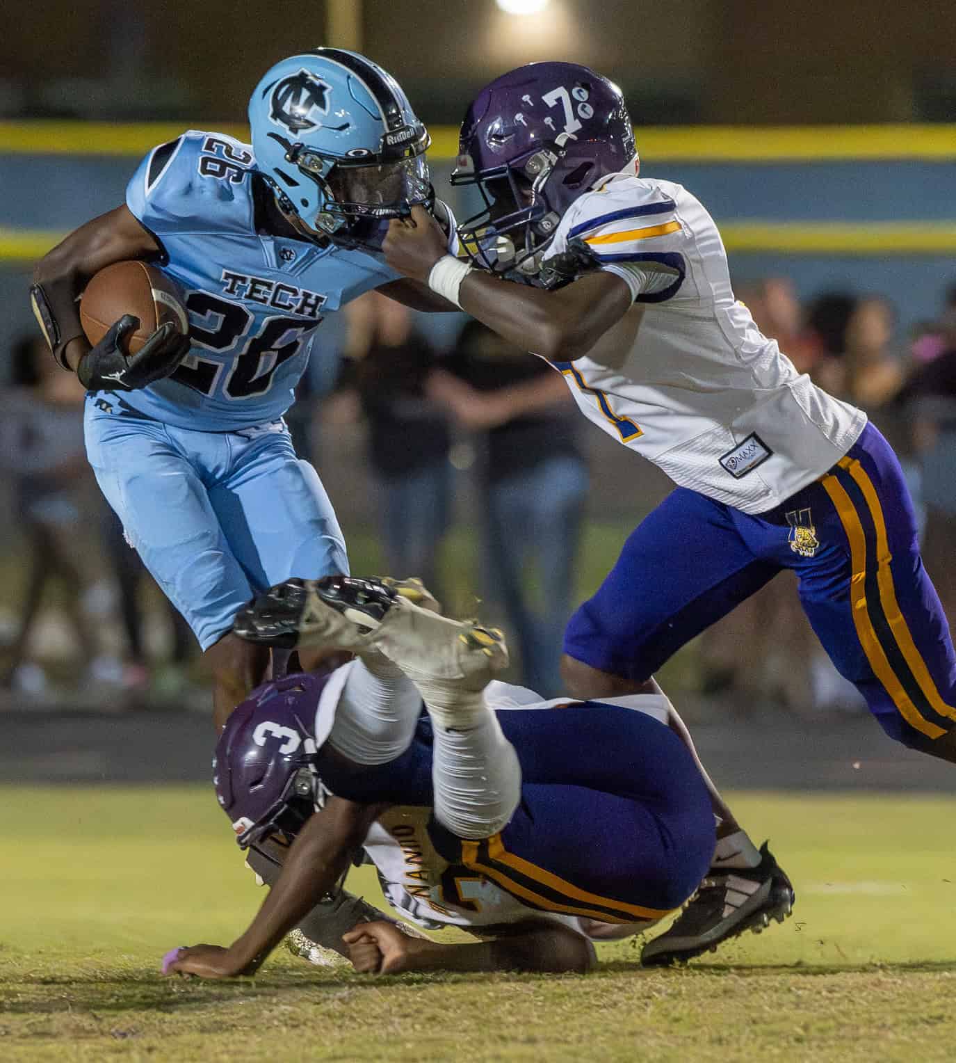 Nature Coast Tech, 26, has his progress stopped by Hernando High's ,7, Carlon Arnold and a grasp of the facemask. [Photo by Joe DiCristofalo]