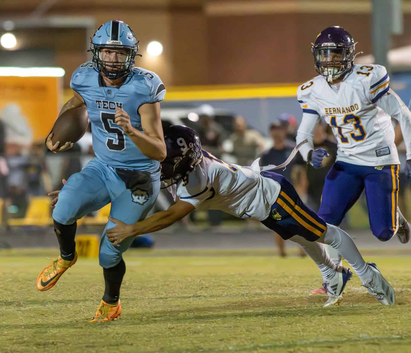 Nature Coast Tech QB, 5, Jackson Hoyt tries to escape the pocket and the tackle by Hernando High's ,9, Isaiah Williams. [Photo by Joe DiCristofalo]