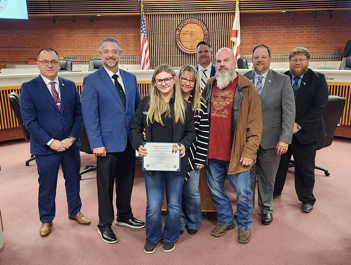 Averie Kimelton receives certificate for her bravery and heroism in rescuing stranded animals at the the board of County Commissioners meeting on Tuesday. [Photo by Austyn Szempruch]