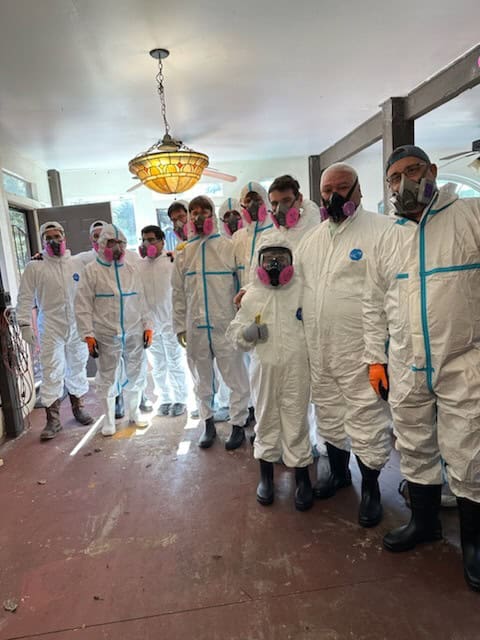 A crew of volunteers outfitted in Tyvek suits, during a Ridge Manor home muck and gut in Ridge Manor on Saturday, Nov. 23, 2024. [Courtesy of Cynthia Rogers]