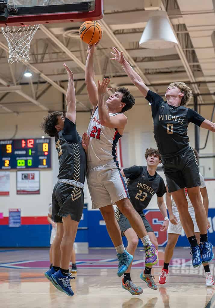 Springstead High's, 21, Jamin Pond shoots a basket while surrounded by Mitchell High defenders Friday at Springstead. [Photo by Joe DiCristofalo]