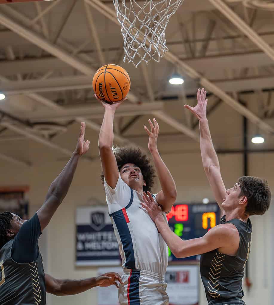 Springstead High's Alejandro Arenas shoots a basket between Mitchell High defenders Friday at Springstead . [Photo by Joe DiCristofalo]