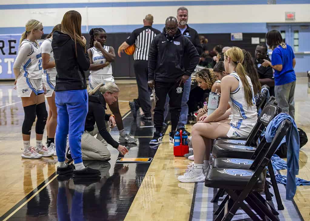 NCT players huddle around the coach to review strategy during a game break at Nature Coast Technical High School in Spring Hill, Fla., on Thursday, December 12, 2024.