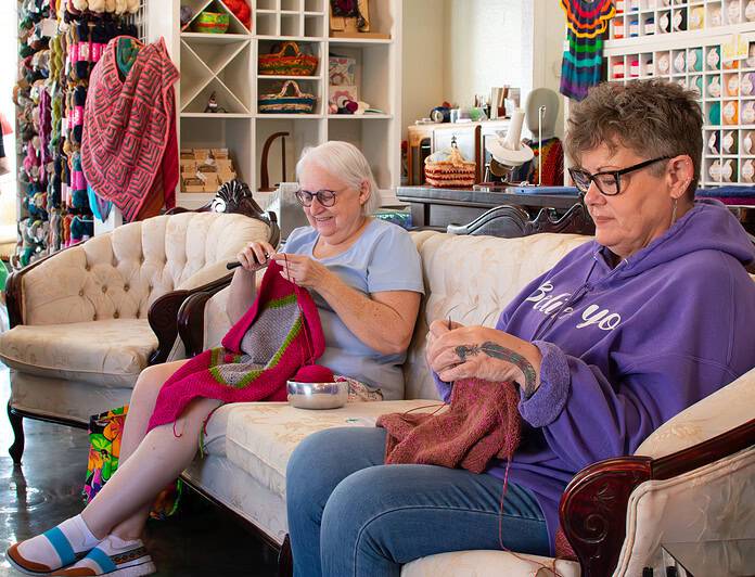 Panbanged Knits and Fibers Shoppe regulars Betsy Draine and Mary Toth enjoy a day of knitting with friends during Small Business Saturday, November 30, 2024. [Credit: Jenifer Truitt]