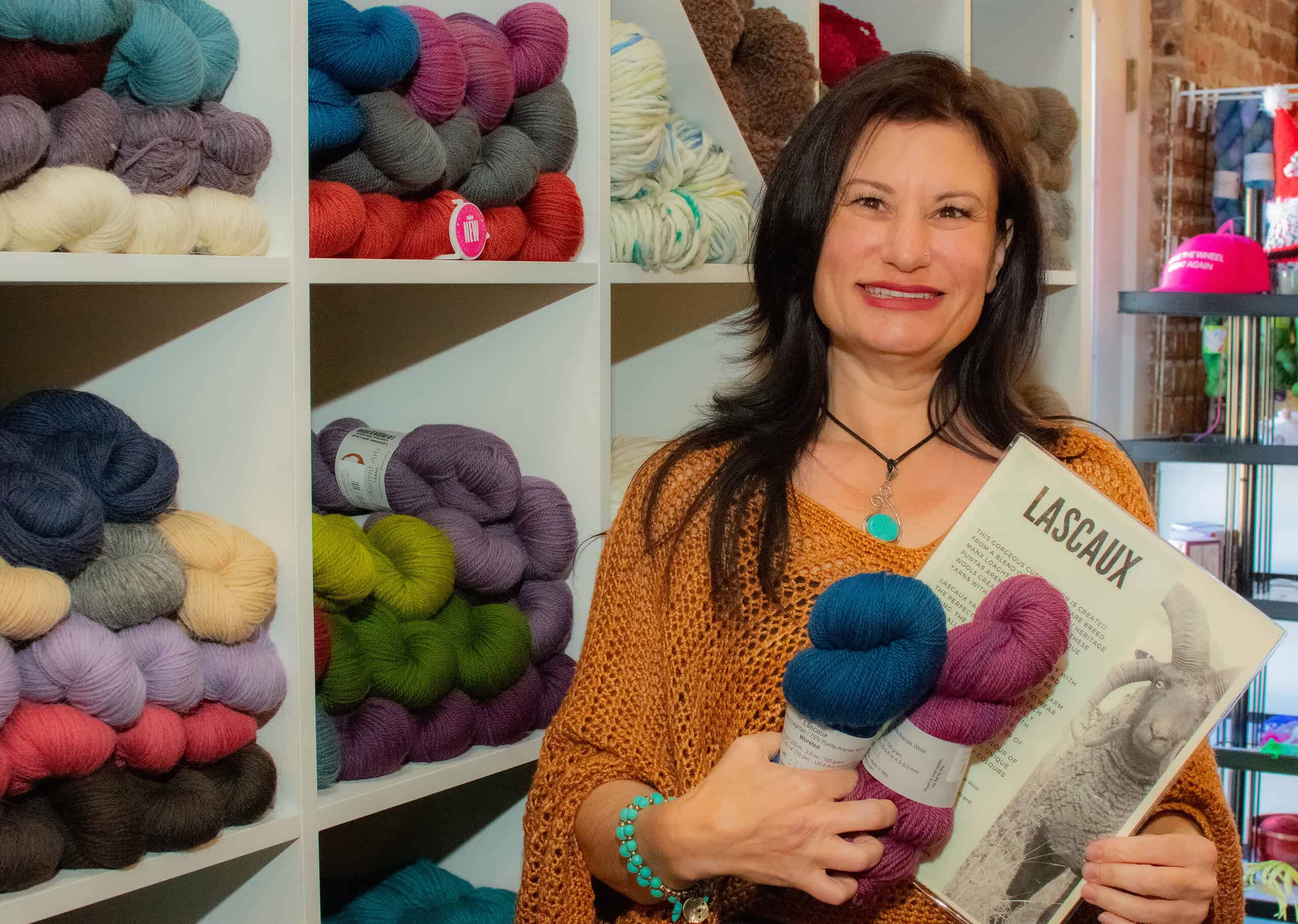 Christen Brandl, owner of Panbanged Knits and Fiber Shoppe, highlights her skeins of Lascaux wool, which come exclusively from four-horned sheep on The Isle of Mann, on Small Business Saturday, November 30, 2024.  
[Credit: Jenifer Truitt]