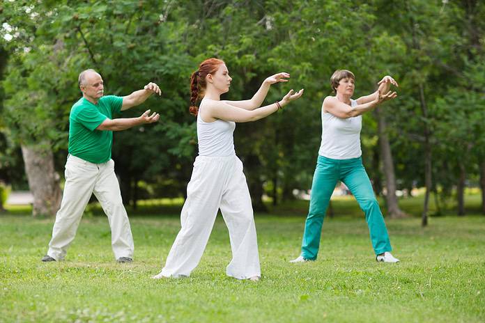 group of people practice Tai Chi Chuan in a park. Chinese management skill Qi's energy.