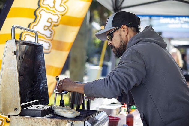 Joey Morales brushes butter onto pretzels at Booksville Festival in Brooksville, Fla., on Saturday, January 25, 2025. (Photo by Hanna Maglio)