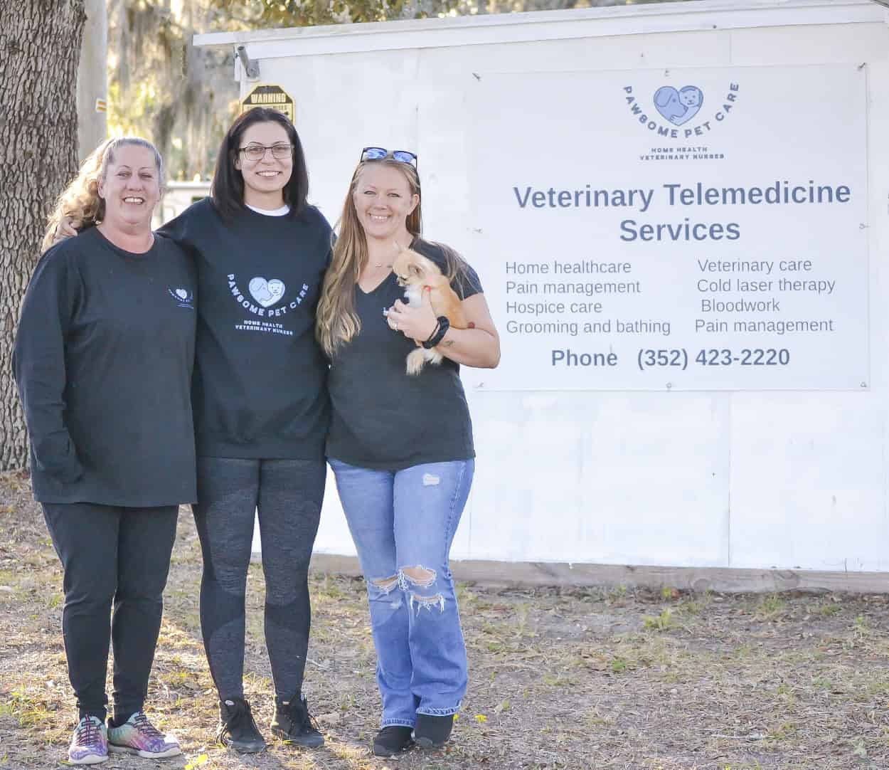 From left, Diane Poulin, Victoria Sullivan and Alina Adams holding Cali pose in front of the newly opened physical location of Pawsome Pet Care, at 10990 South Suncoast Boulevard (U.S. 19) in Homosassa, just north of the Hernando County line. [Credit: Chris Bernhardt Jr.]