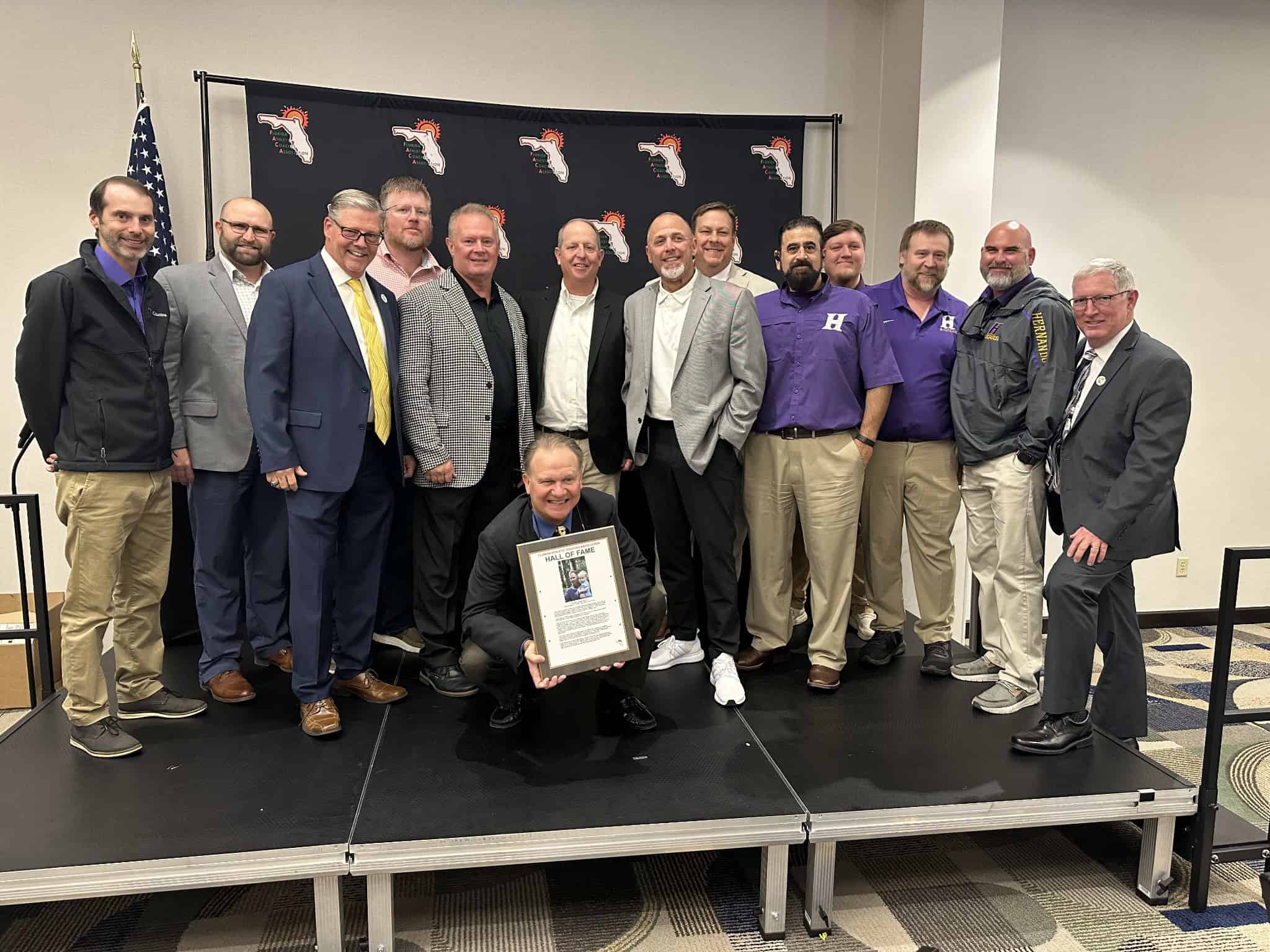 Tim Sims (seated) surrounded by current and former HHS assistant coaches at FACA Hall of Fame induction ceremony. [Photo courtesy of Patrick Skipper]