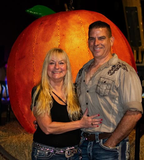 On New Year’s Eve, Brooksville’s iconic tangerine was a popular backdrop for photos. Engaged couple Beverly Stewart and Rodney Shaffer pause for a photo at the Tangerine Drop December 31, 2024. . [Photo credit Jenifer Truitt]