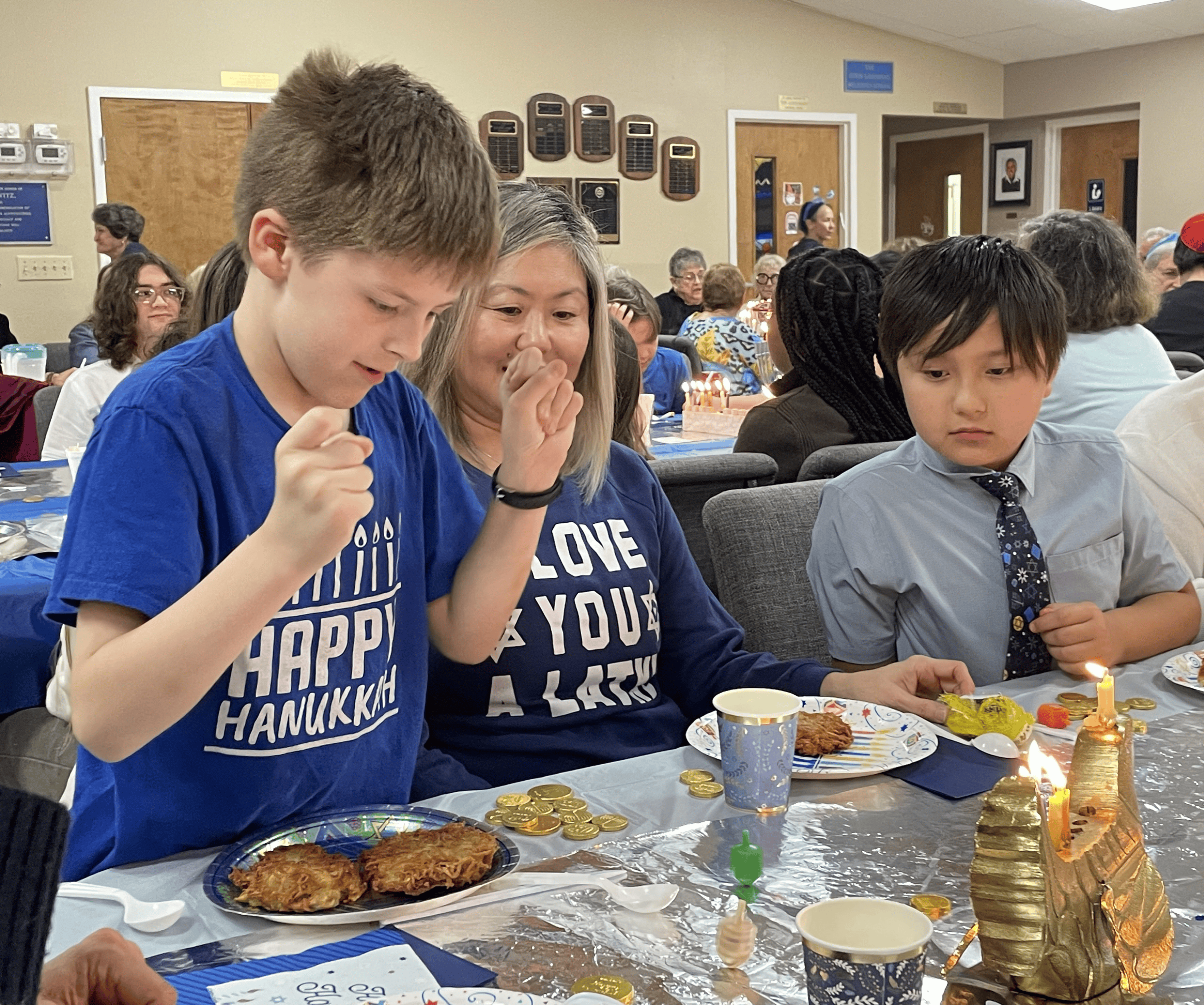 (L-R) Logan Evans spinning his dreidel, Lauren Marretta, Fox Marretta [Photo by Sarah Nachin]