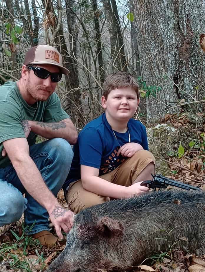 Sean Cummins and Hunter Watson with the trophy hog taken along the Withlacoochee River near Nobleton. [Photo by Toby Benoit]