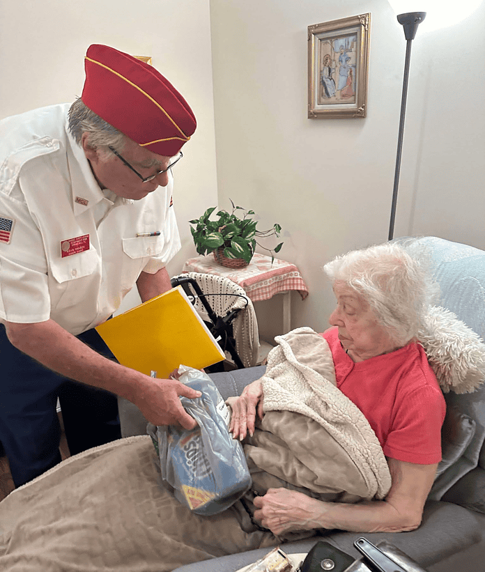 A member of the Wish List program presented a box of cookies to a nursing home resident last year. [Photo courtesy of MCL 708]